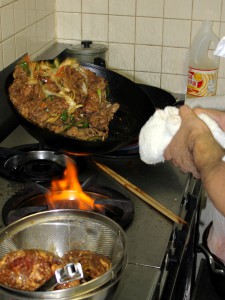 # 厨房にて。見事な鍋さばきで肉と野菜をいためます