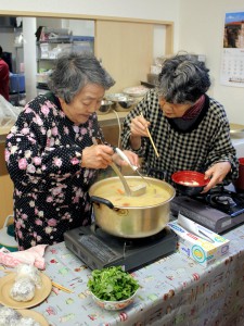 # 食事提供準備中の1コマ。おいしいお雑煮を召し上がっていただくために、味のチェックに余念がありません